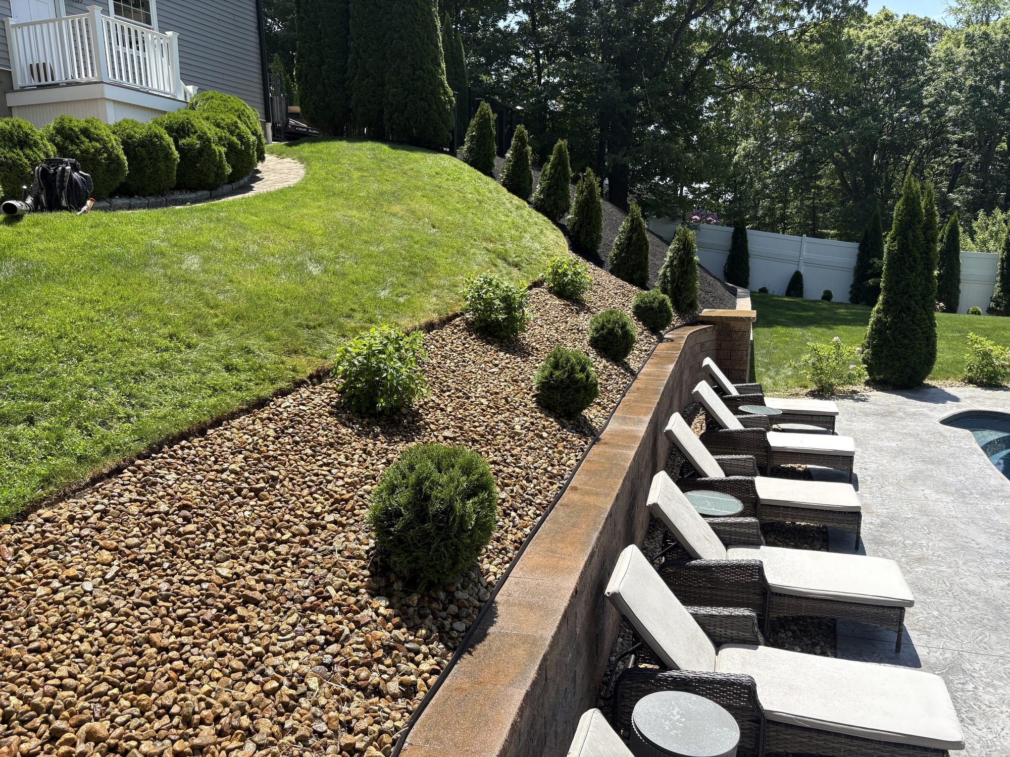 Retaining wall, stone bed and poolside patio