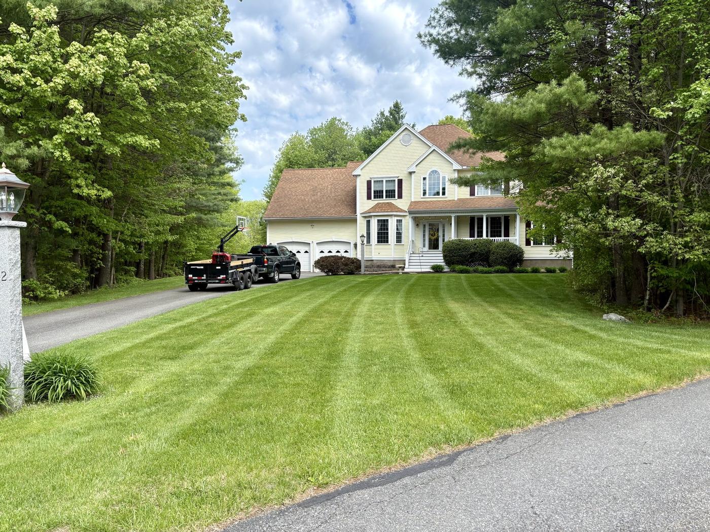 Barefoot truck and trailer in the driveway of a freshly mowed property